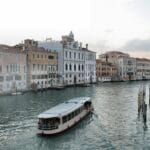 Łódź na spokojnym kanale w Wenecji między historycznymi kamienicami