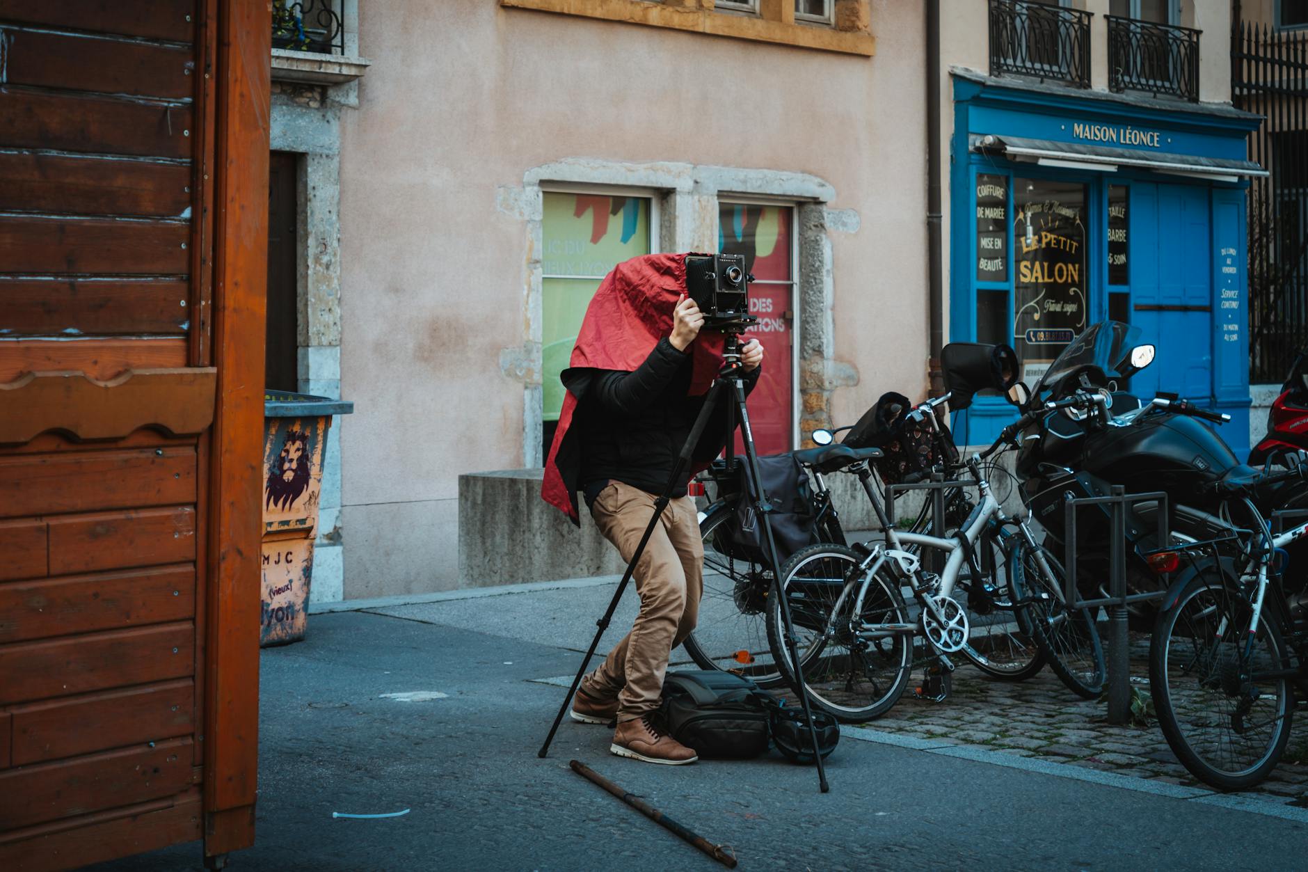Fotograf z analogowym aparatem na ulicy wśród rowerów w Bremie