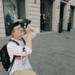 Mężczyzna z aparatem analogowym fotografuje miasto w retro stylu