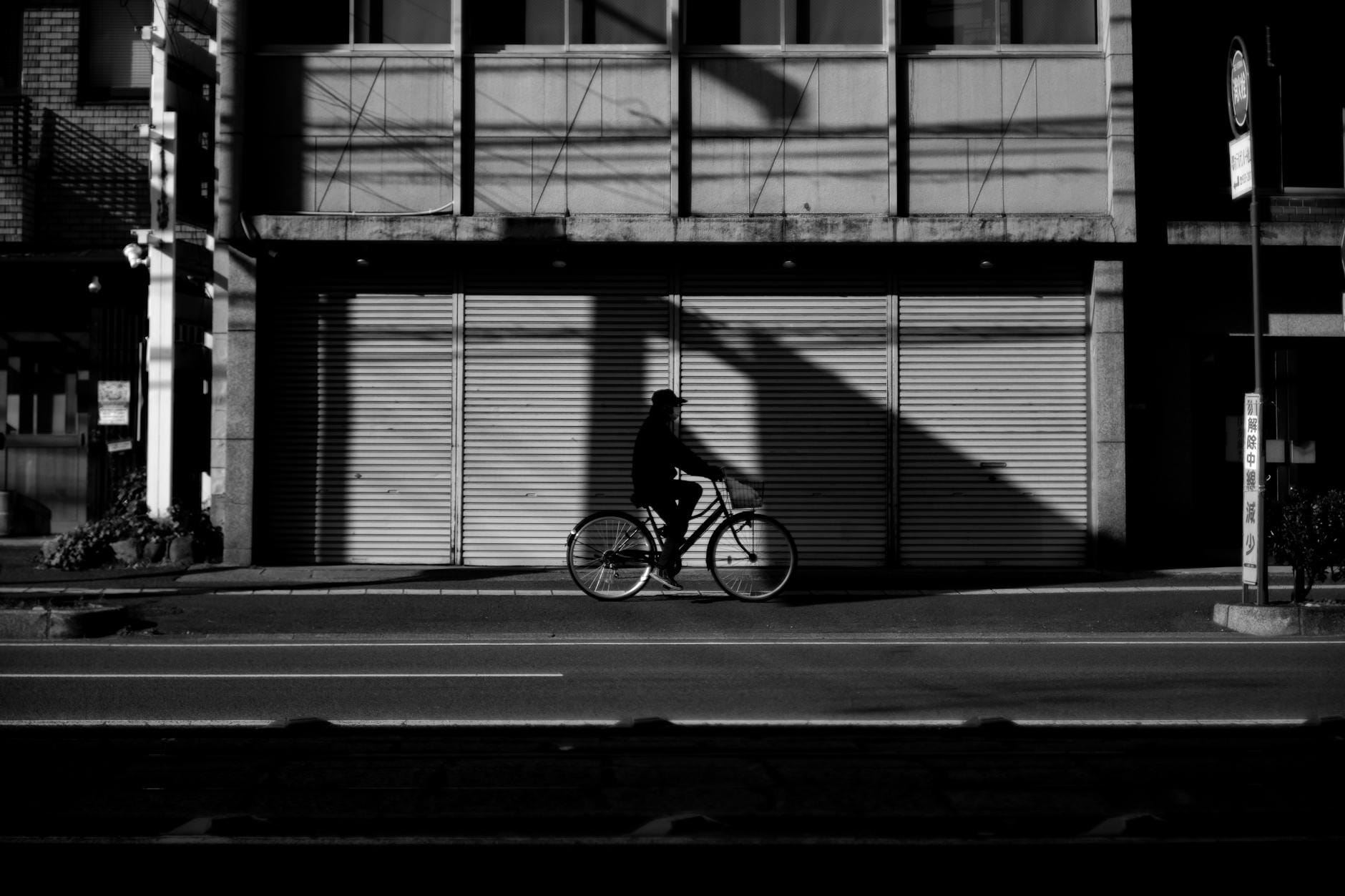 Sylwetka rowerzysty jadącego ulicą między budynami w Bielefeld