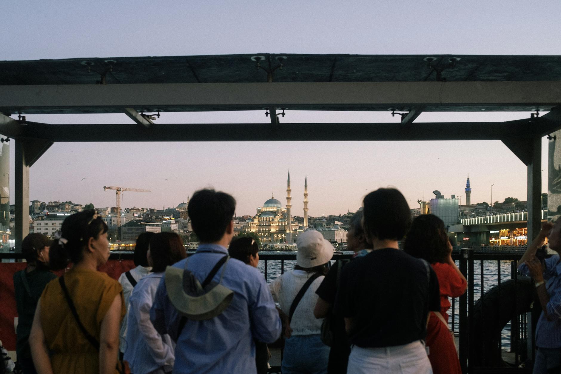 Turyści o zmierzchu fotografują panoramę miasta z meczetami