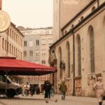 Urokliwa ulica z historyczną zabudową i ogródkiem kawiarnianym