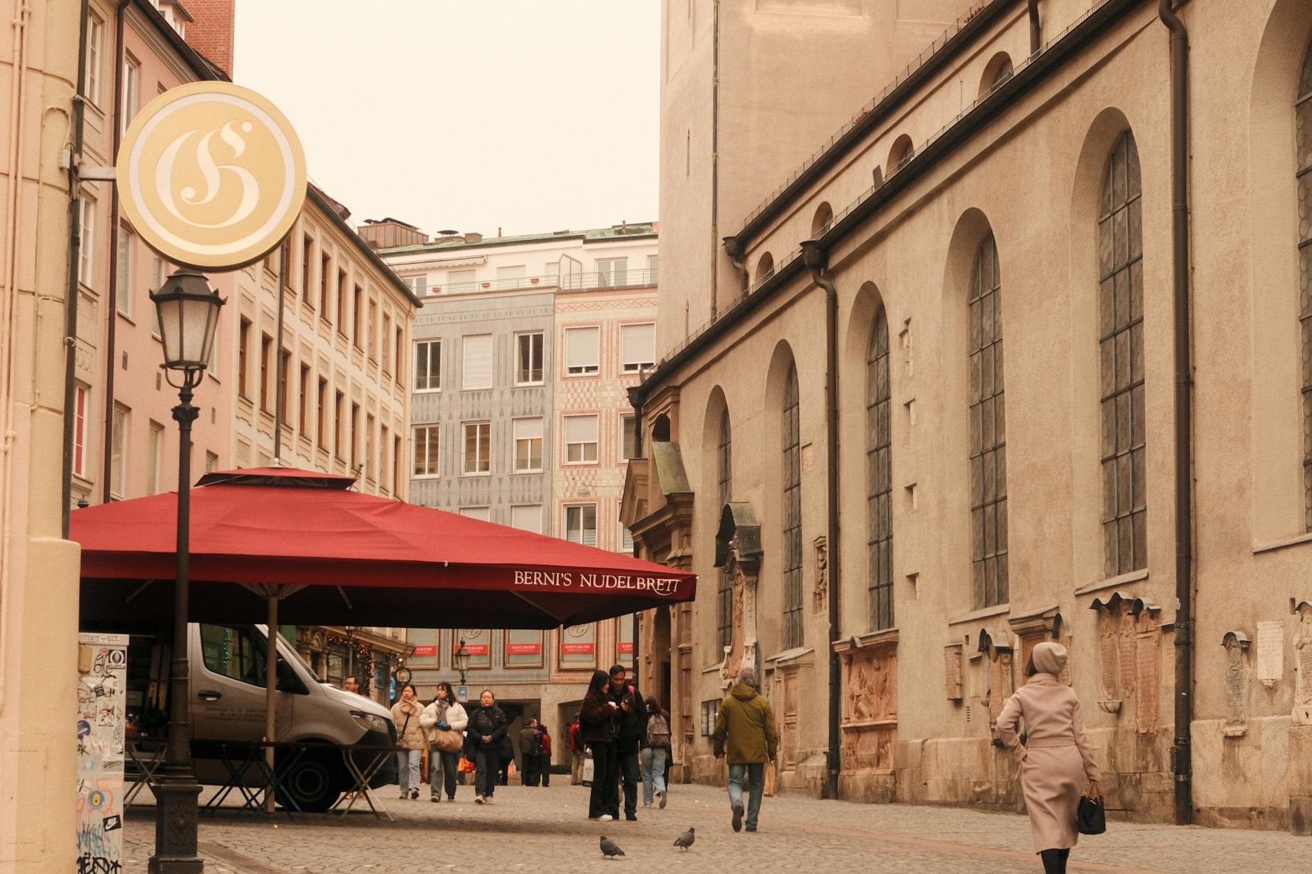 Urokliwa ulica z historyczną zabudową i ogródkiem kawiarnianym