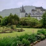 Schloss Münster za alejką ogrodową wśród bujonej zieleni