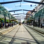 Ruchliwy przystanek tramwajowy w Dreźnie z ludźmi i nowoczesną zabudową