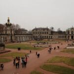 Panorama dziedzińca Zwingeru w Dreźnie z turystami i barokową fasadą